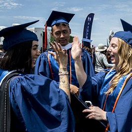 two female graduates giving each other a high-five