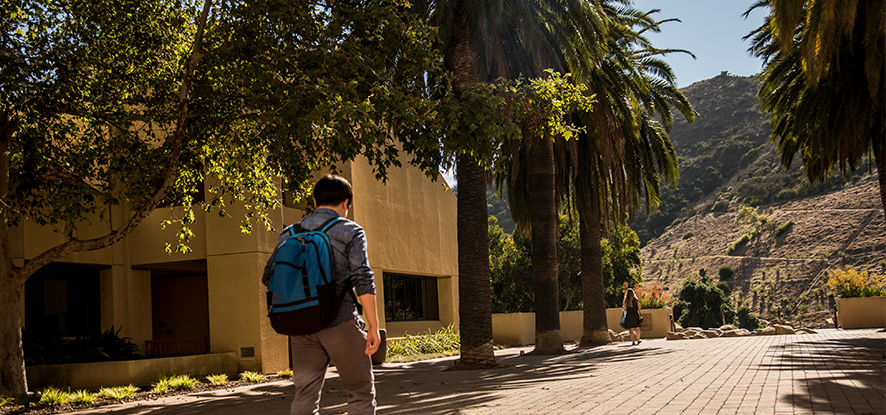 Student walks on GSEP Malibu campus on a sunny day.