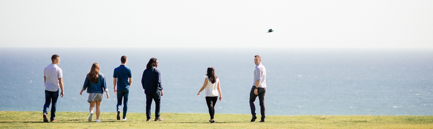students on lawn overlooking ocean