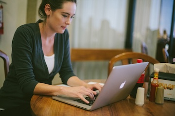 Student sitting at a table with information folders