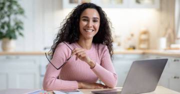 Woman sitting at her computer smiling