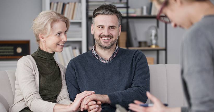 Happy couple speaking with a therapist