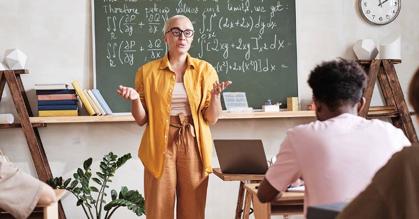 Teacher talking to students at the front of the classroom