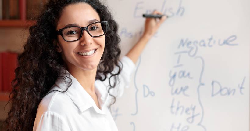 Woman smiling while writing on the board