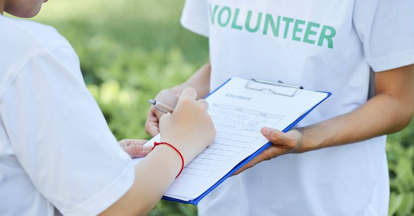 Person signing a volunteer form