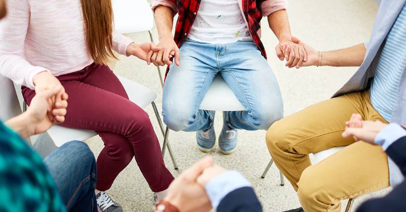 People holding hands in group therapy