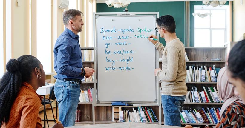 Teacher working with a student at a whiteboard