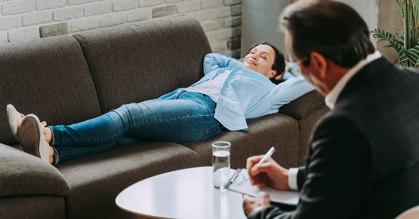 Patient laying on couch with therapist