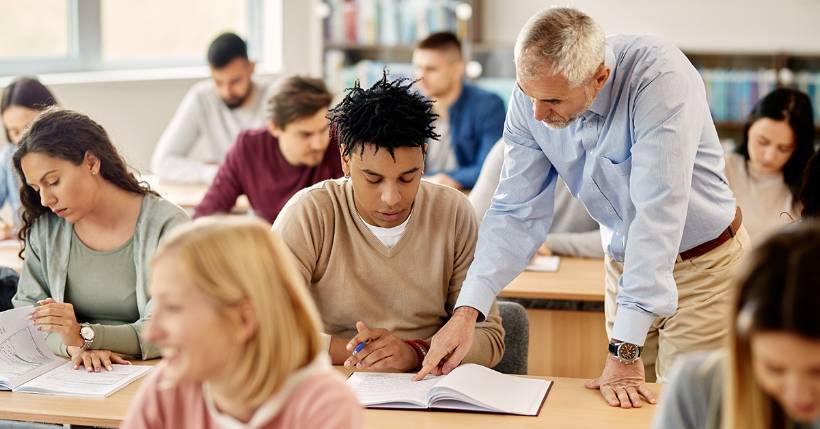 Teacher helping student at desk