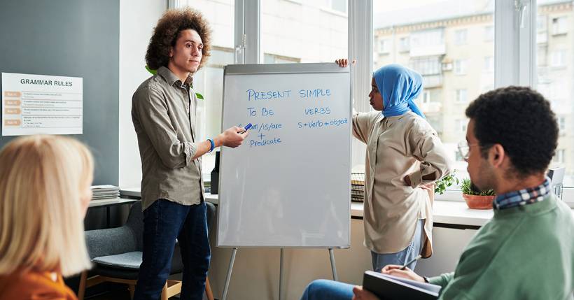 Man and a woman speaking in front of a whiteboard