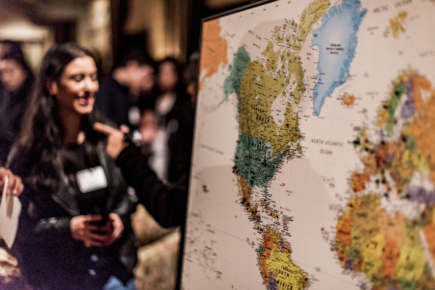 doctoral student talking off to the side of a world map