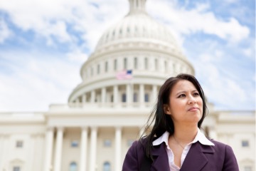 Woman in suit stands in front of capitol building in Washington, D.C.