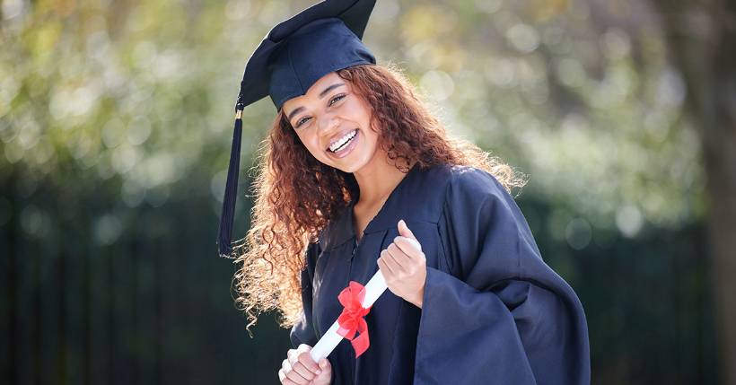 Graduate proudly holding diploma