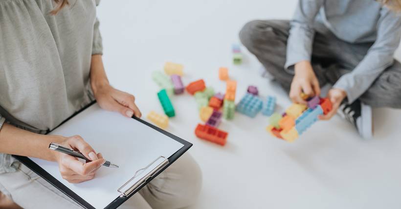 Therapist observing a child that is playing with blocks