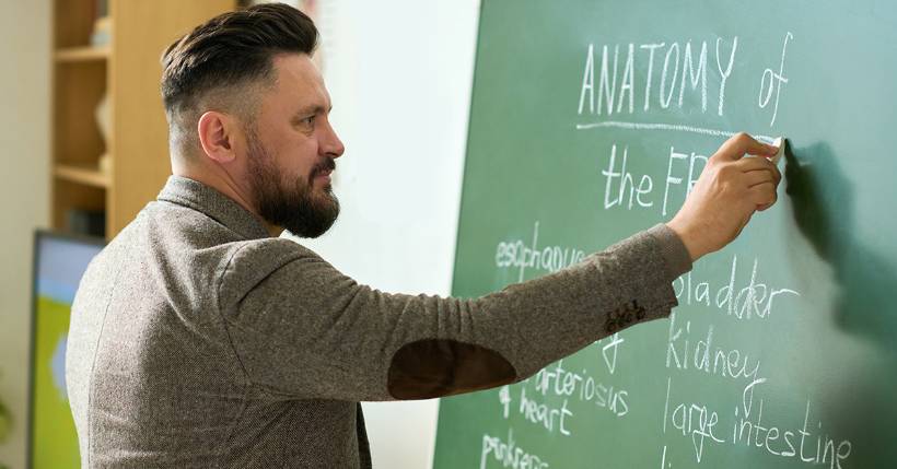 Teacher writing on chalkboard