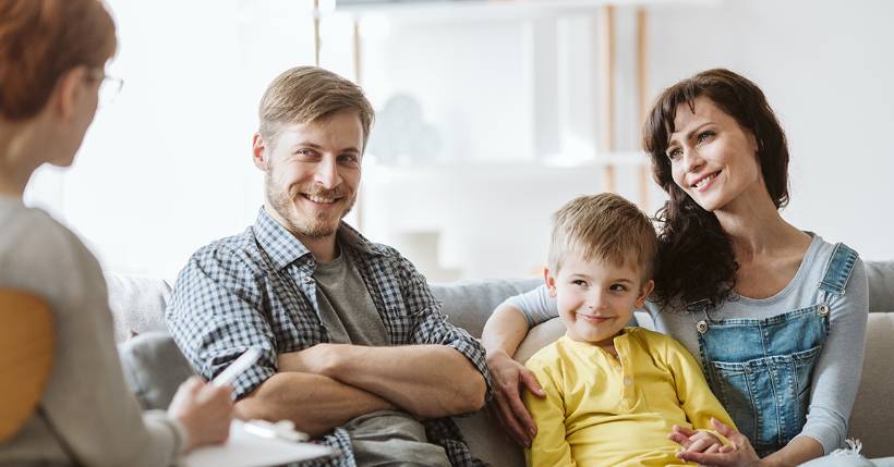 Smiling family talking with their therapist