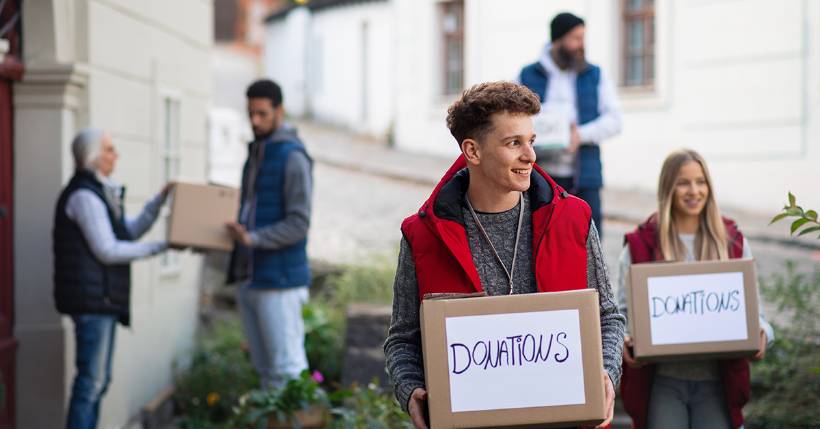 Volunteers holding donation boxes