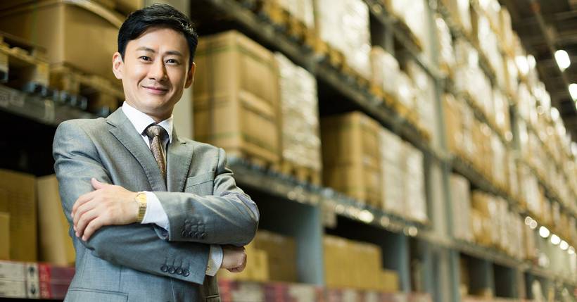 Male entrepreneur proudly standing in his warehouse