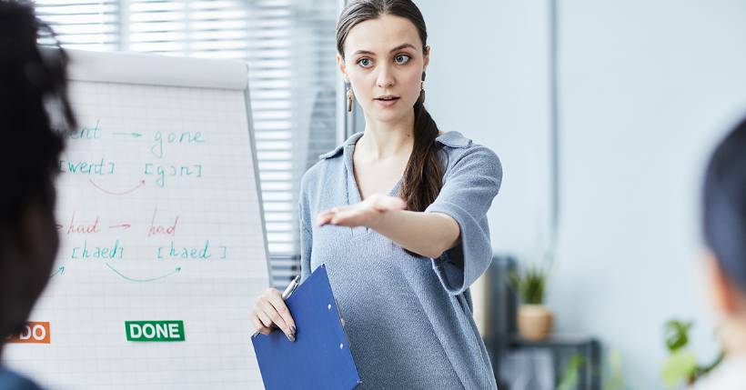 Teacher standing in front of her class teaching