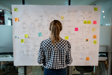 woman designing a plan and facing away from the camera