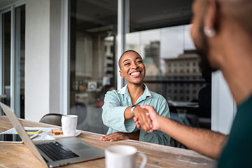 young African American woman shaking hands with an African American man