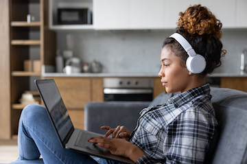 young woman on her laptop with headphones on