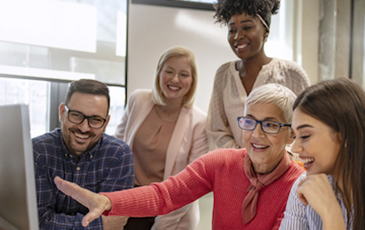 a diverse group looking at a computer together