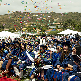 graduates celebrating at their ceremony with confetti in the air