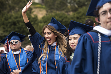 Female graduate waving at Commencement