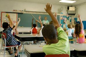 student raising their hand in a classroom
