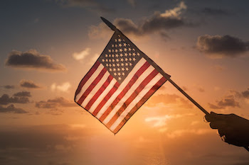 US flag waving in the sunset