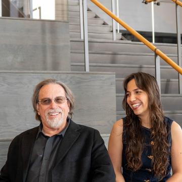 Dr David Levy and Nataliane Martins sitting and smiling