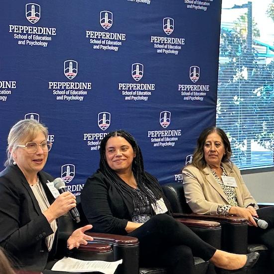 Three women sitting on a panel discussing