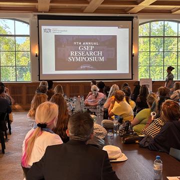 attendees of the research symposium listening to the opening remarks at the chateau
