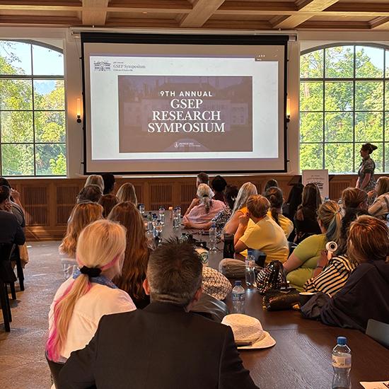 attendees of the research symposium listening to the opening remarks at the chateau
