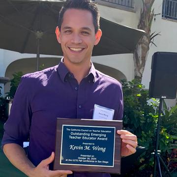 Kevin Wong holding award plaque