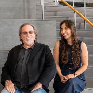 Dr David Levy and Nataliane Martins sitting and smiling