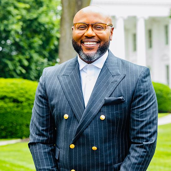 Dr. Nii-Quartelai Quarty standing outside in a blue pinstripe suit