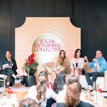 Four entrepreneurs sitting on stage talking to an audience about social impact