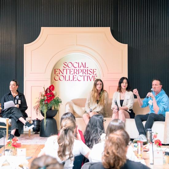 Four entrepreneurs sitting on stage talking to an audience about social impact